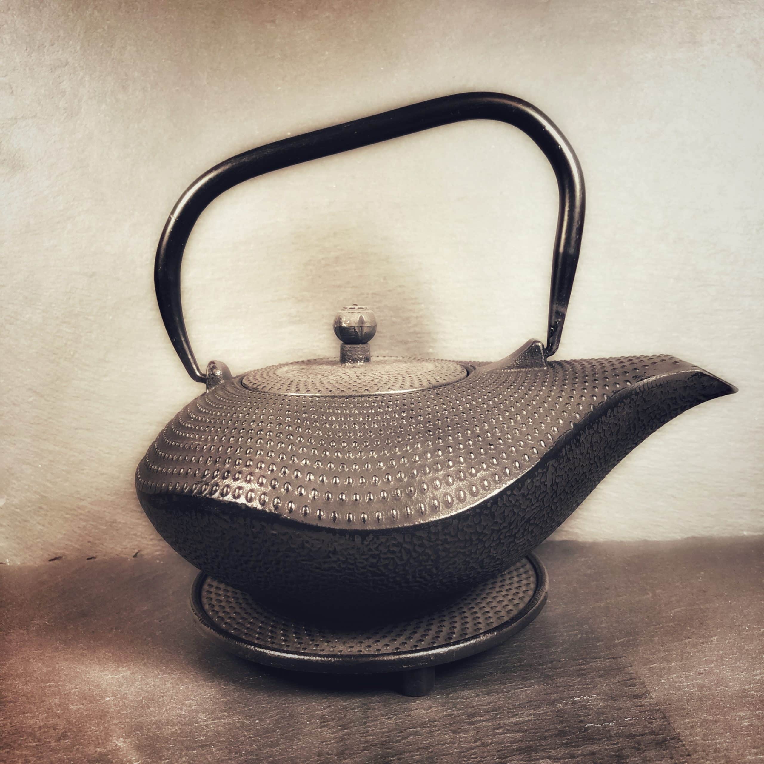 Black hobnail cast iron teapot with a curved wave like shape